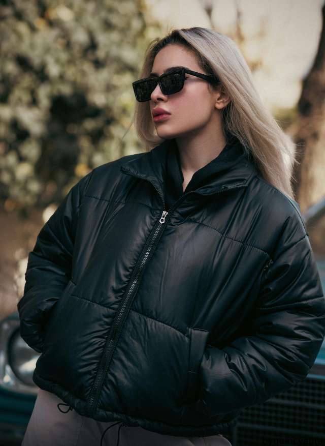 Woman wearing a black cropped puffer jacket