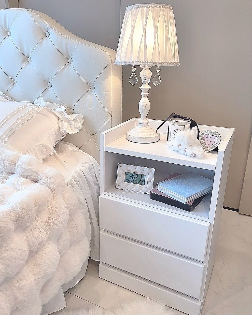 A small bedroom with a modern, minimalist nightstand next to the bed. 