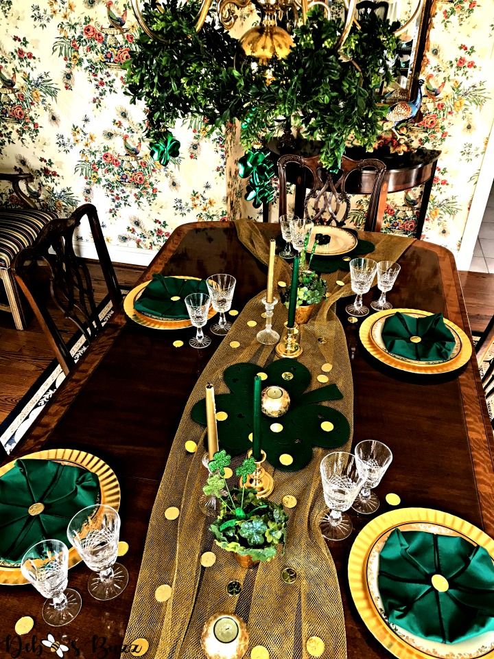 Green and neutral candles of varying heights arranged on a cozy St. Patrick’s Day table.