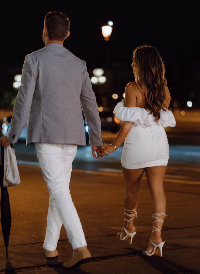 A couple holding hands while walking in a park