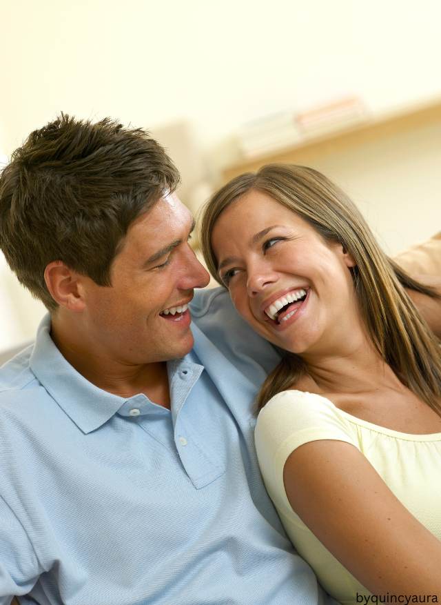 A couple sitting together laughing.