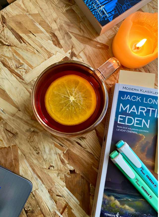 A calm morning setup with a candle, a journal, and a cup of tea on a clean wooden tabl