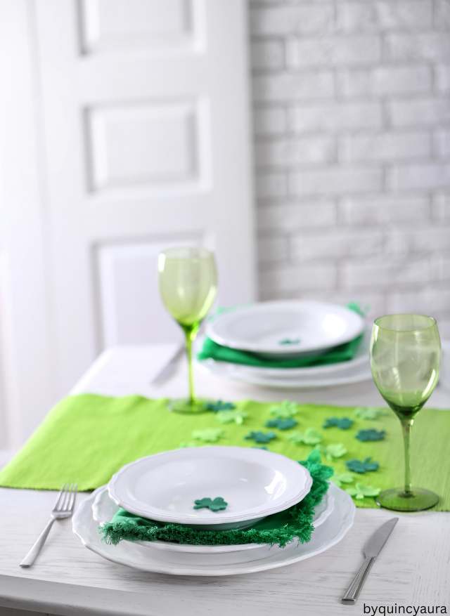 A cozy dining table with a sage green linen table runner for st patricks day.