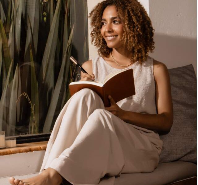 An image of a girl sitting beside the window.