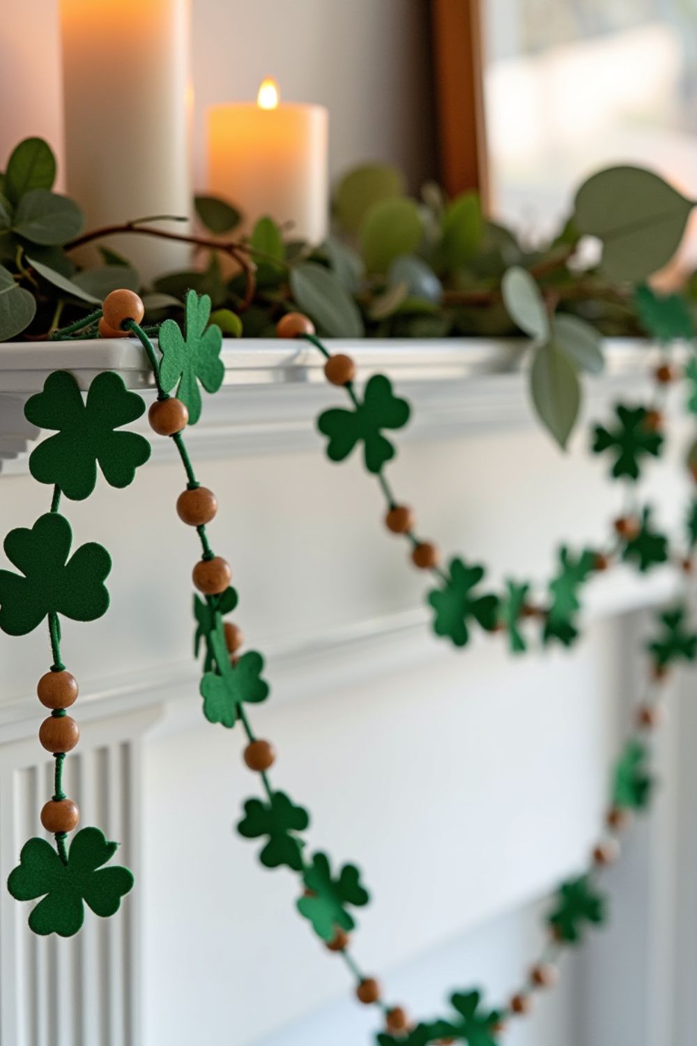 A close-up of a green shamrock garland hanging on a neutral wall