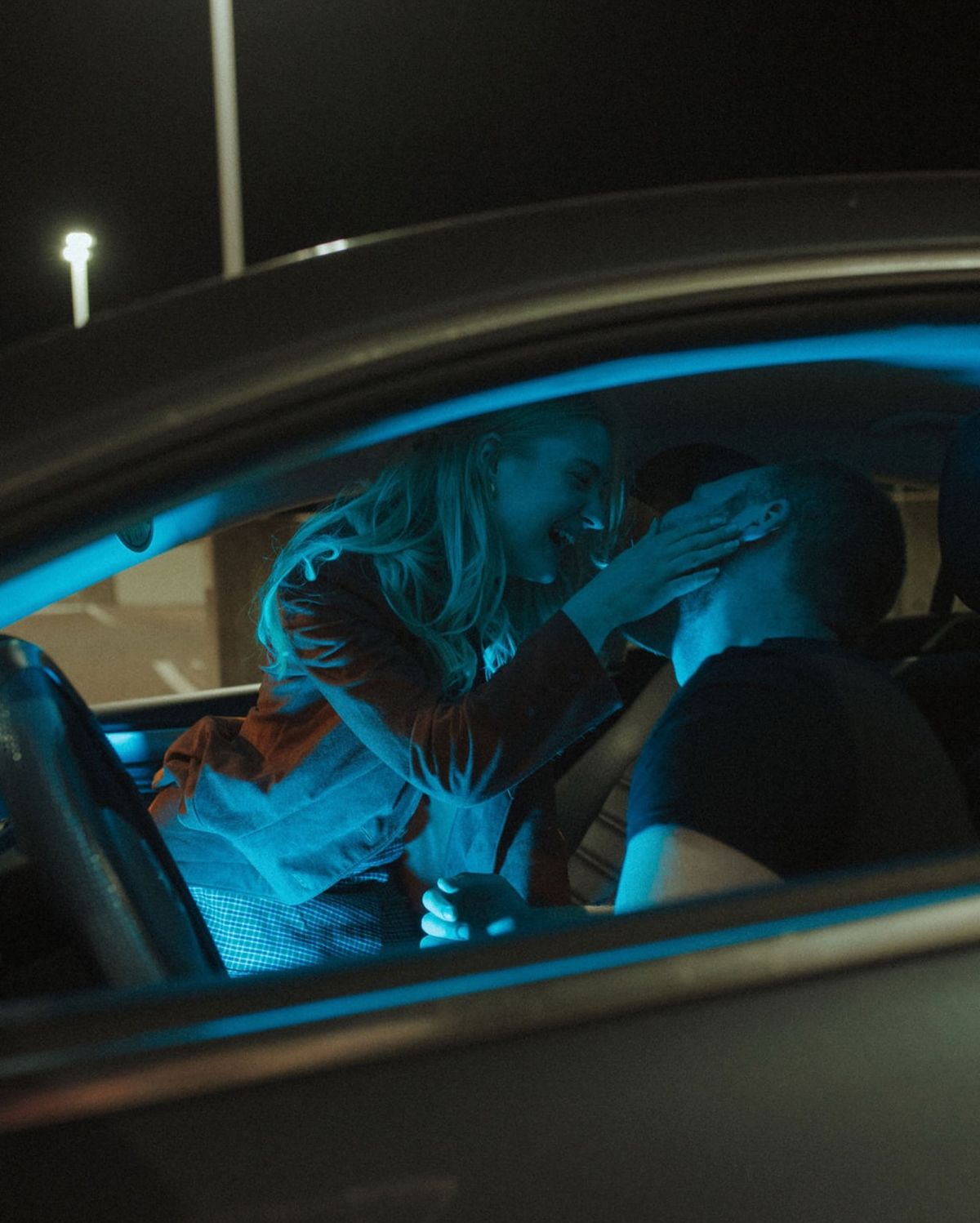 A couple sitting in a car at night 