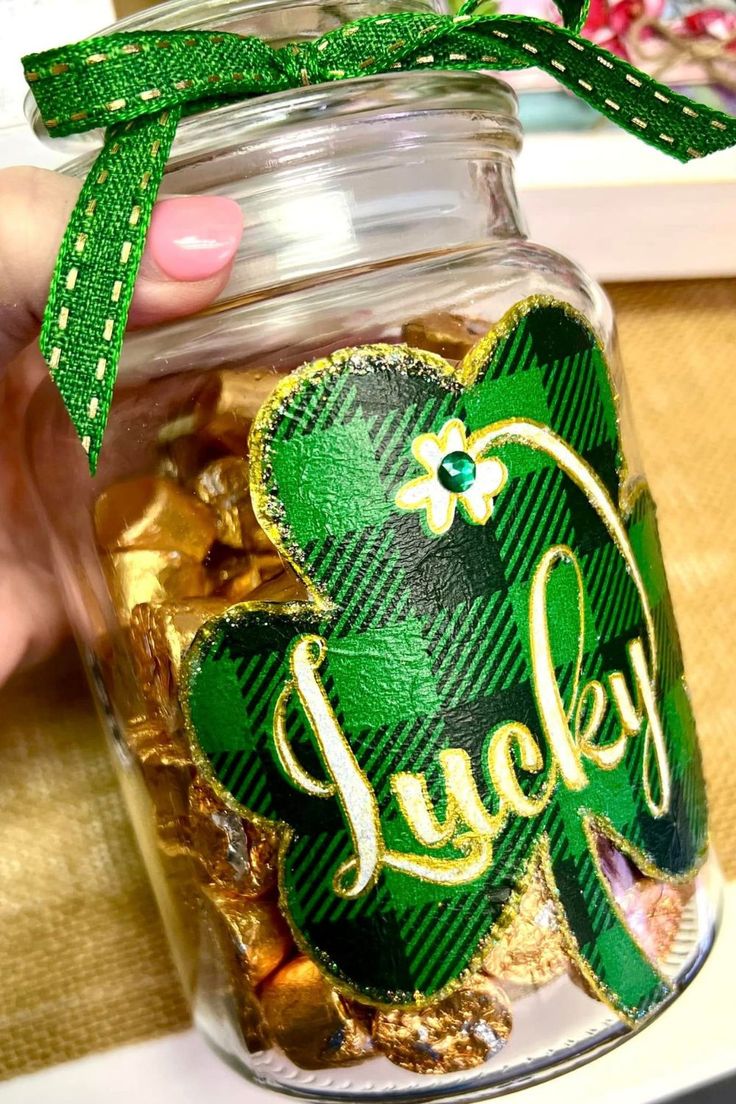 A small mason jars filled with green beads, shamrocks, and gold coins.