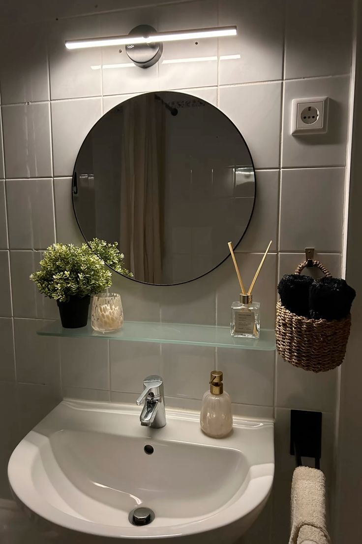 A small bathroom with a chic round mirror.