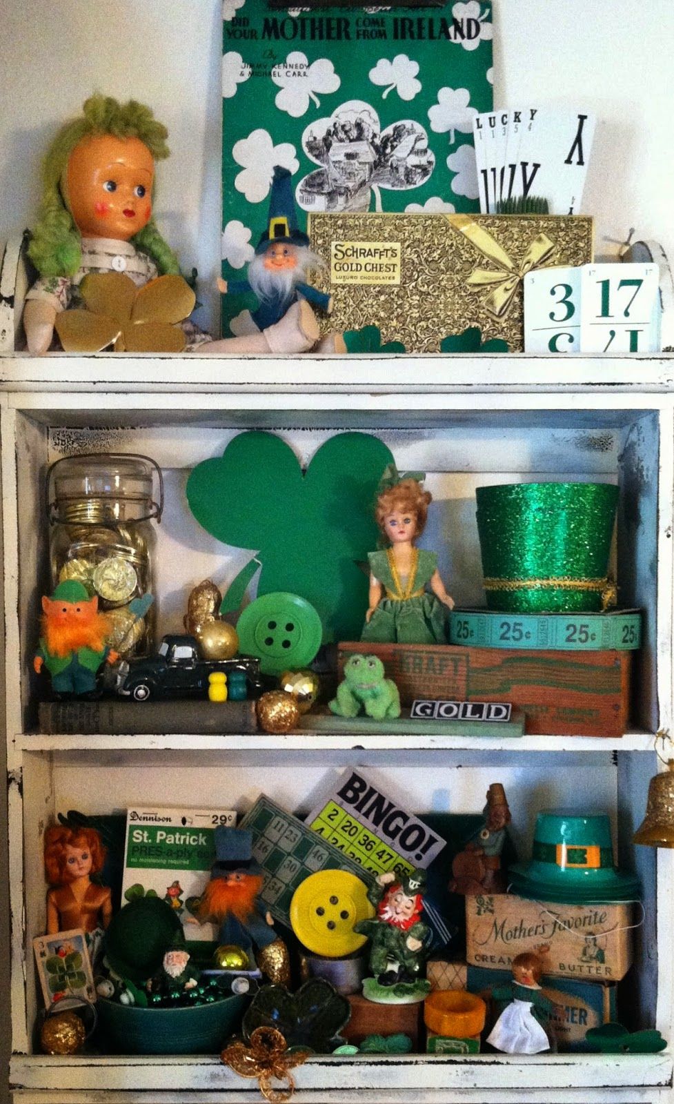  shelf with small green ceramic vases and glass decor piece