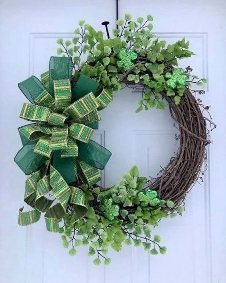 A simple grapevine wreath decorated with faux shamrocks and a green ribbon.