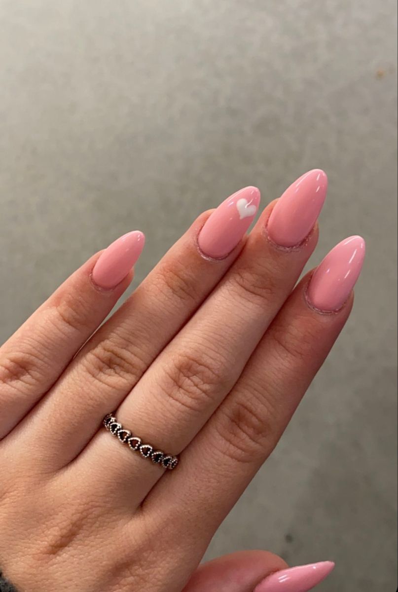 Matte baby pink Valentine’s Day nails with a glossy heart accent.
