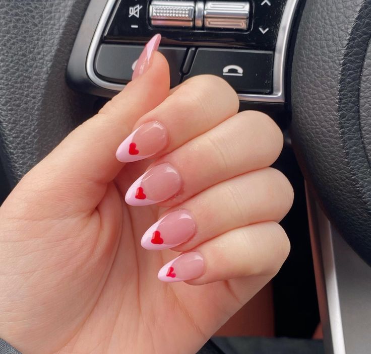 Medium-length almond nails with pink French tips and small heart details.