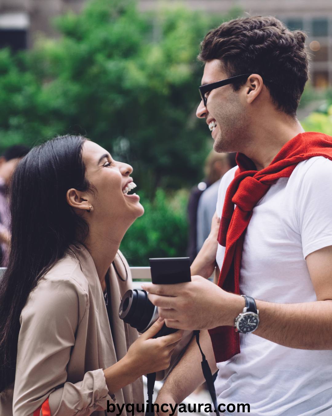 A couple dressed in stylish Valentine’s Day outfits, laughing and posing together.