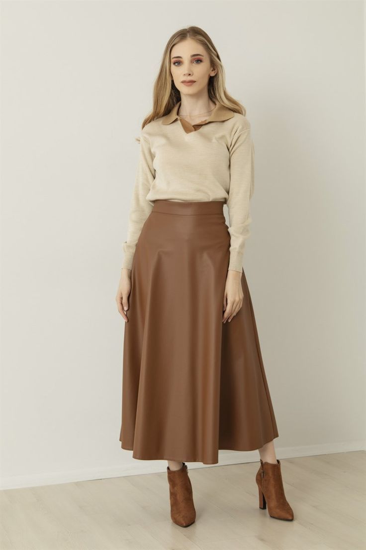 Brown knee-high boots worn with a midi skirt.