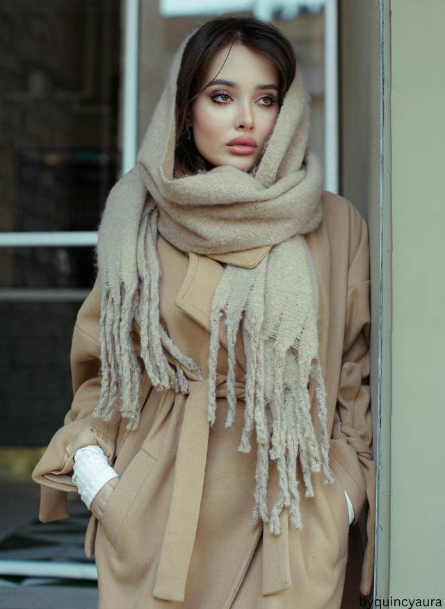 A winter outfit featuring dark base layers with a beige coat, pastel scarf as an accent.