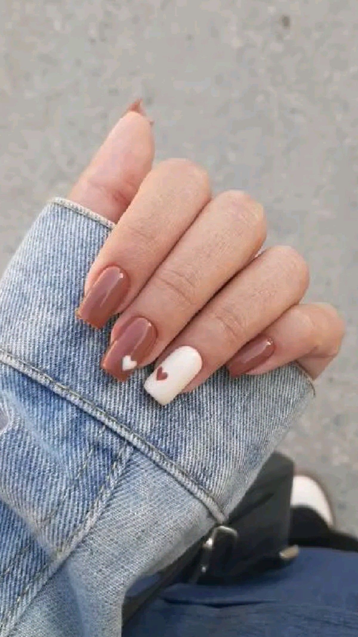 Chocolate brown Valentine’s Day nails with tiny pink heart accents.