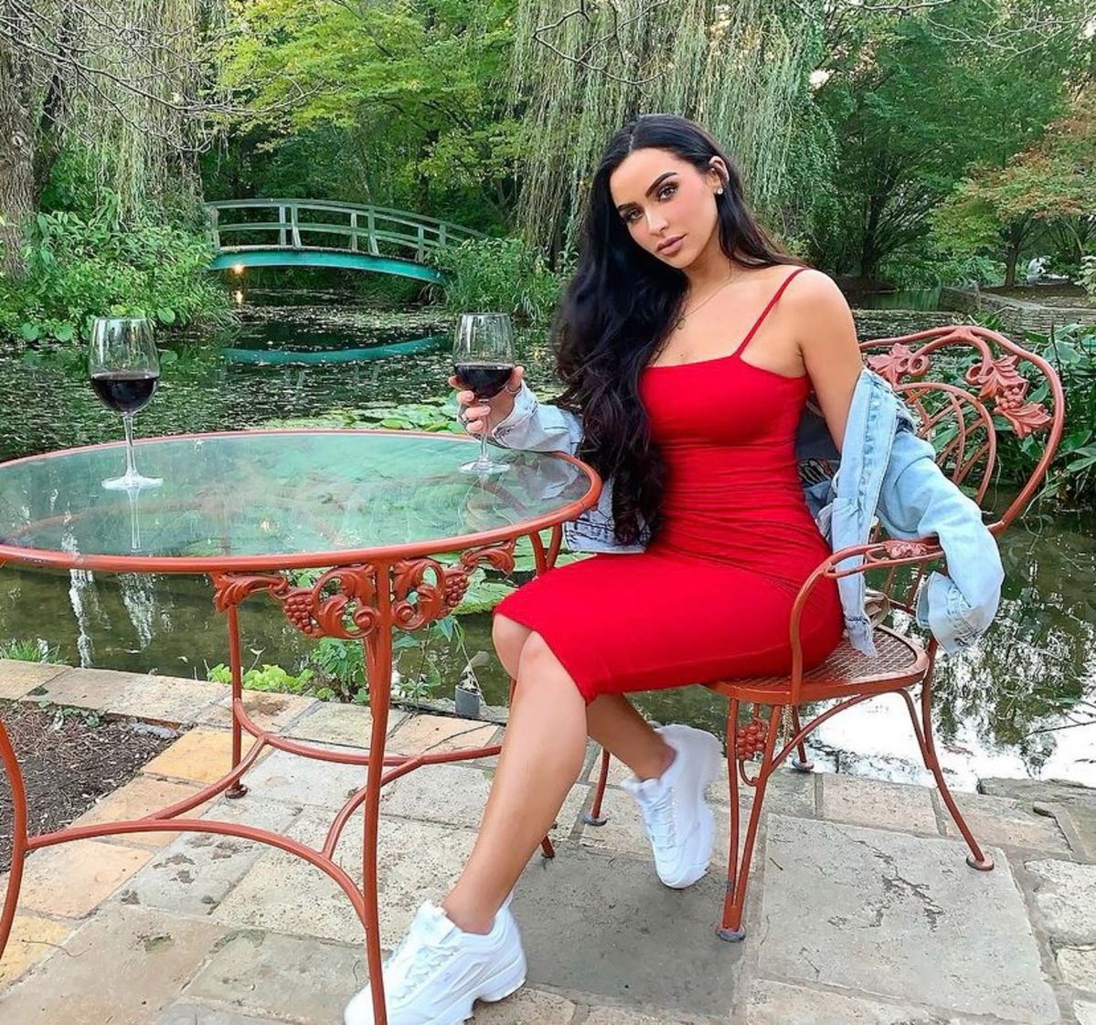 A lady putting on a red dress casual outfit with sneakers