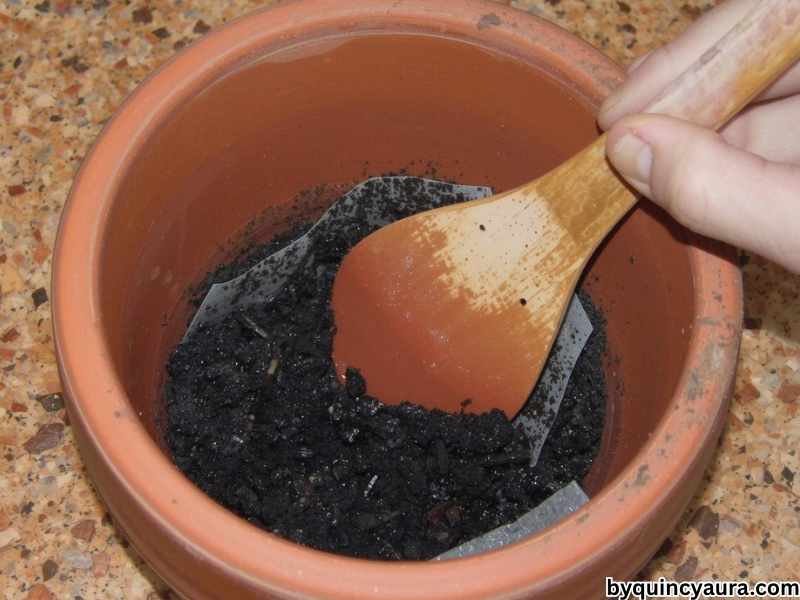 A bright, soft-lit close-up of hands applying a clear sealer or Mod Podge to a painted terra cotta pot using a wide brush, showing a glossy finish forming on colorful designs, set on a clean white or light wooden table