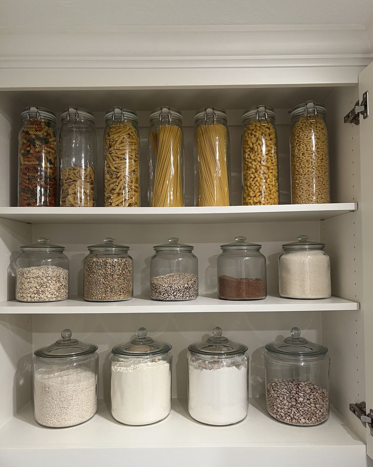 Clear glass jars filled with flour, pasta, coffee